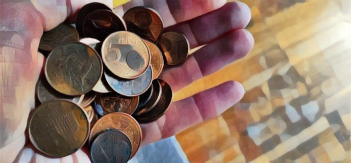 Hand mit Centstücken als Symbol für Lohnanspruch